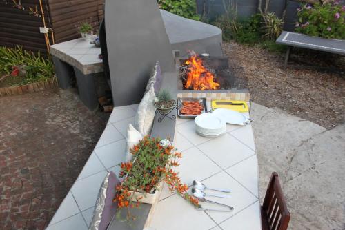 a white table with a grill with food on it at Pelican Lodge Guesthouse in Sedgefield