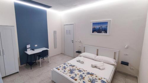 1 dormitorio con cama, escritorio y lavamanos en Marricrio House en Catania