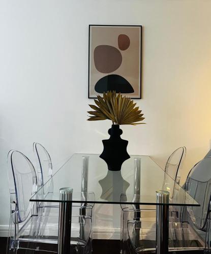 a glass dining room table with chairs and a lamp at 2 Bedroom Penthouse Birmingham in Birmingham