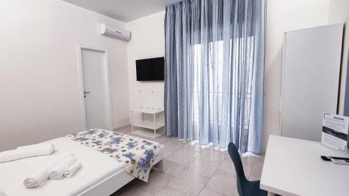 een kamer met een bed, een bureau en een raam bij Marricrio House in Catania