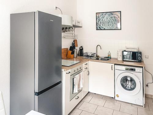 a kitchen with a refrigerator and a washer and dryer at Zentrum, 2R, Balkon, WiFi, 4P, modern, ruhig in Chemnitz