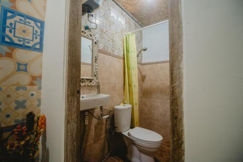 een kleine badkamer met een toilet en een wastafel bij Samblung Mas House in Denpasar