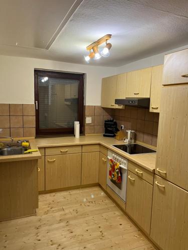 a kitchen with wooden cabinets and a sink and a stove at Landhaus inklusive Parkplatz in Schotten