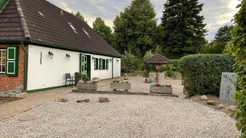 uma casa com um pátio de cascalho em frente em Gemütliches Landhaus in Harmsdorf em Harmsdorf