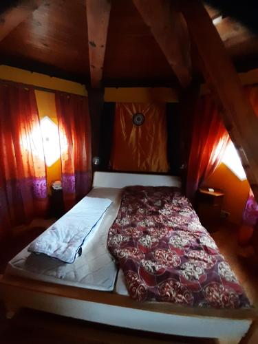 uma cama num quarto de madeira com cortinas em Väderkvarn em Höganäs