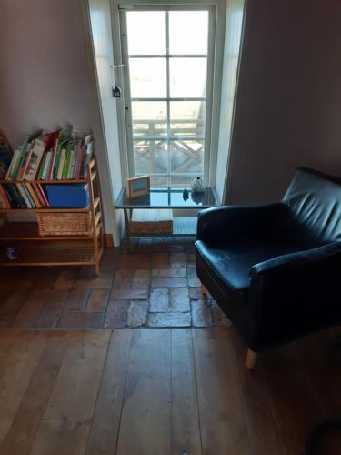 uma sala de estar com um sofá, uma mesa e uma janela em Väderkvarn em Höganäs