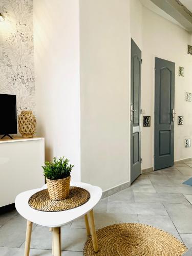 a room with a table with a potted plant on it at BE MY APPARTS, Studio de charme "LE CARILLON", DOUAI, Coeur de ville in Douai