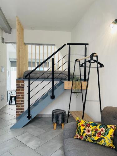 a spiral staircase in a living room with a couch at BE MY APPARTS, Studio de charme "LE CARILLON", DOUAI, Coeur de ville in Douai
