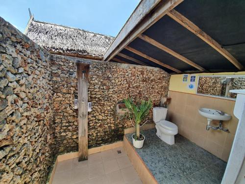 ビラにあるScuba Republic Beach Bungalowsの石壁のバスルーム(トイレ付)