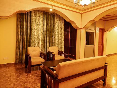 a living room with a couch and chairs and a table at Divine Hills Mashobra in Shimla
