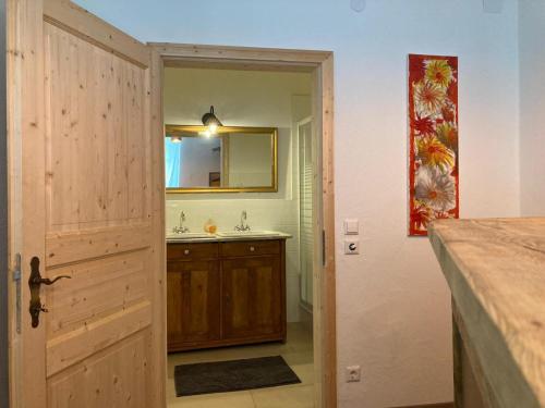 a bathroom with a sink and a mirror and a door at Perschlingtalhof in Auern