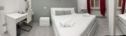 a white bedroom with a bed and a desk at One Hundred Rooms in Rome