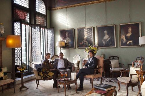 a group of people sitting in a room with portraits at Palazzetto Pisani Grand Canal in Venice