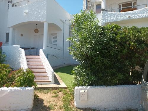 a house with white walls and stairs and plants at Apartament Port de la Selva in Port de la Selva