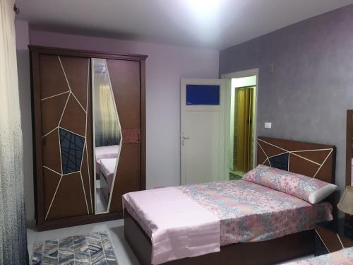 1 dormitorio con cama y armario con espejo en Furnished Apt At Mohandeseen families only, en El Cairo