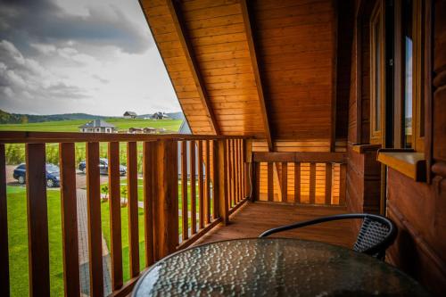 a balcony with a table and a view of a field at Domki w Bieszczadach - Apartamenty in Hoczew