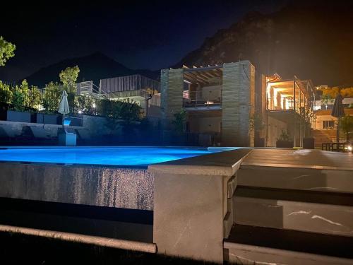 a swimming pool at night with a building at Sibenbras Natural Aparthotel in Limone sul Garda