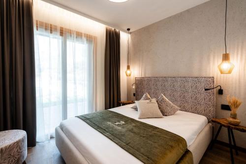 a bedroom with a bed and a large window at Sibenbras Natural Aparthotel in Limone sul Garda