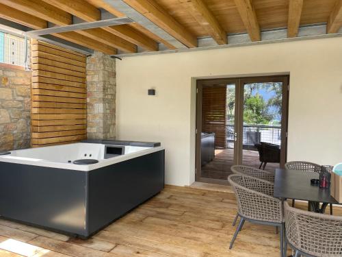 a kitchen with a tub and a table and chairs at Sibenbras Natural Aparthotel in Limone sul Garda