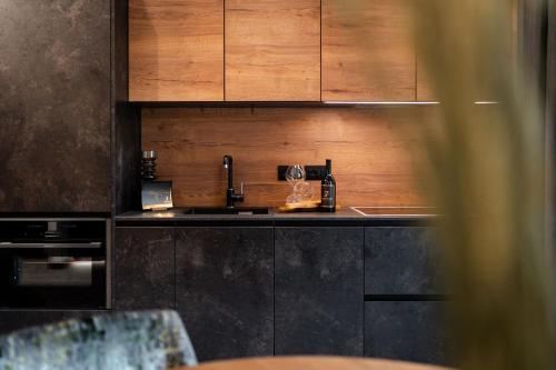a kitchen with a sink and wooden cabinets at Sibenbras Natural Aparthotel in Limone sul Garda