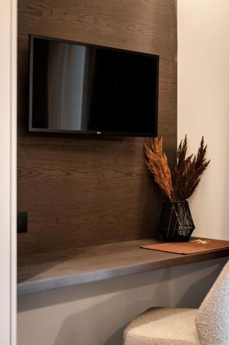 a flat screen tv on a wall with a shelf at Sibenbras Natural Aparthotel in Limone sul Garda
