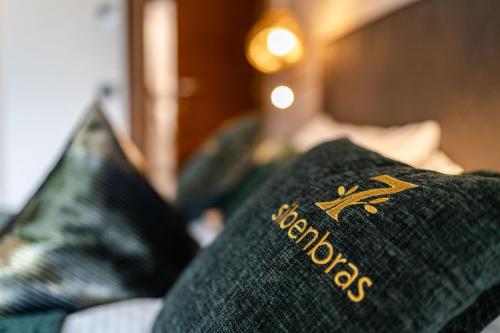 a blanket on a couch with two pillows at Sibenbras Natural Aparthotel in Limone sul Garda