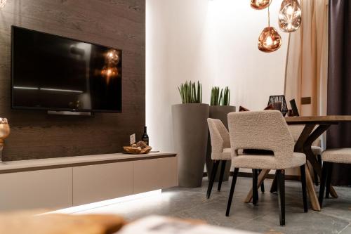 a living room with a tv and a table and chairs at Sibenbras Natural Aparthotel in Limone sul Garda