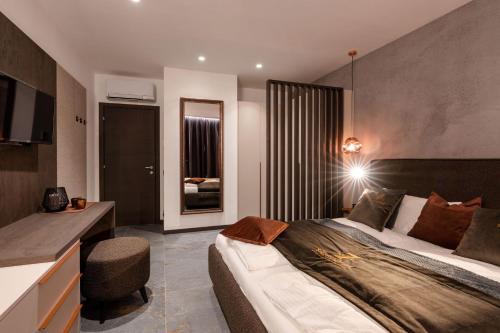 a bedroom with a bed and a desk in a room at Sibenbras Natural Aparthotel in Limone sul Garda