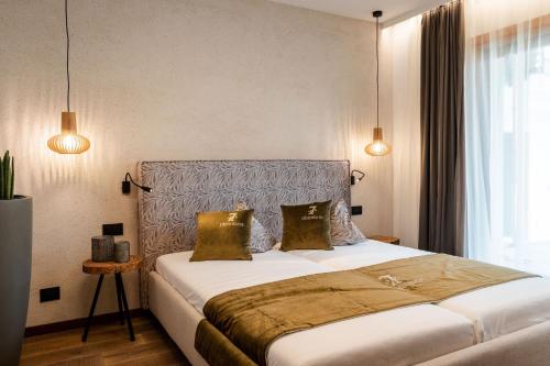 a bedroom with a large bed with two pillows at Sibenbras Natural Aparthotel in Limone sul Garda