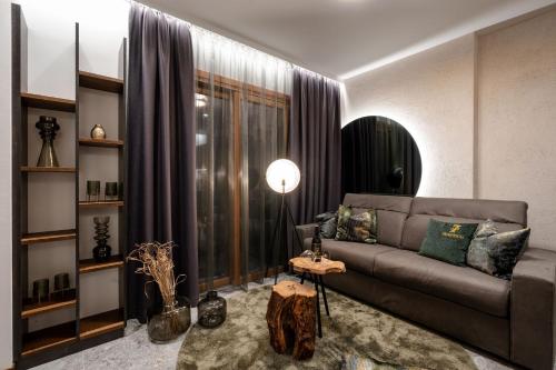 a living room with a couch and a large window at Sibenbras Natural Aparthotel in Limone sul Garda