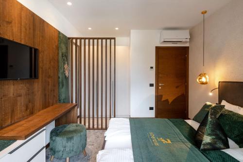 a hotel room with a bed and a television at Sibenbras Natural Aparthotel in Limone sul Garda