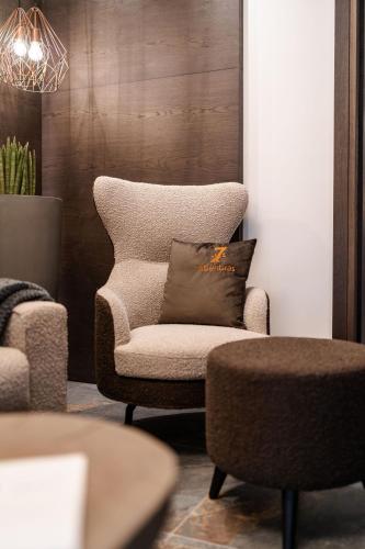 a living room with a chair with a pillow on it at Sibenbras Natural Aparthotel in Limone sul Garda