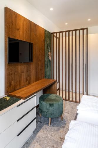 a bedroom with two beds and a tv on a wall at Sibenbras Natural Aparthotel in Limone sul Garda
