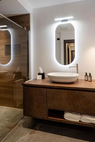 a bathroom with a sink and a mirror at Sibenbras Natural Aparthotel in Limone sul Garda