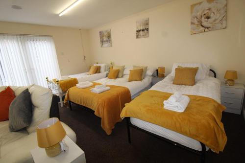 a bedroom with two beds and a couch at Annex at 29B St Ann's in Rotherham