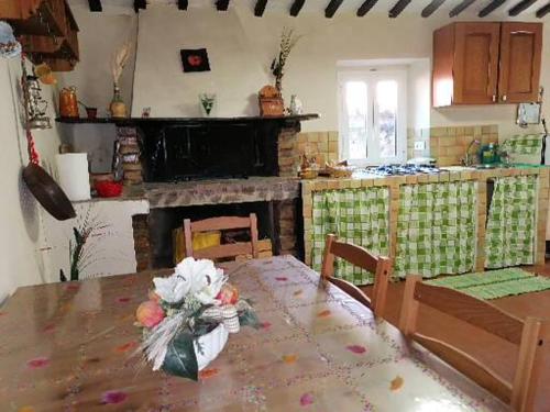 una cocina con mesa y chimenea. en Casa di Olly - Loft incantevole con camino, en Ponticelli