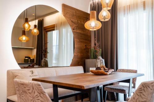 a dining room with a wooden table and lights at Sibenbras Natural Aparthotel in Limone sul Garda