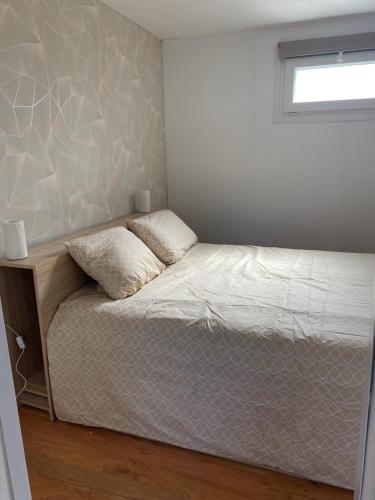 um pequeno quarto com uma cama e uma janela em Petite maison, quartier calme. em Bourges