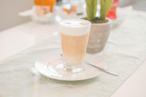 un vaso de bebida en un plato en una mesa en Hotel am Schlossplatz en Hechingen