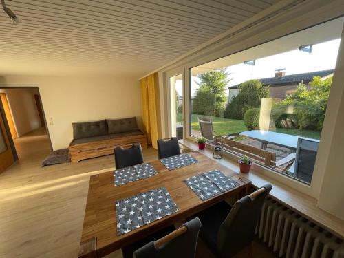 ein Esszimmer mit einem Tisch und einem großen Fenster in der Unterkunft Ferienwohnung Elfengast, FassSauna, Harzurlaub in bester Lage in Bad Harzburg