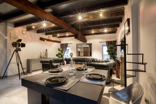 a dining room with a table and leather chairs at La Maison de Maurice in Beaune