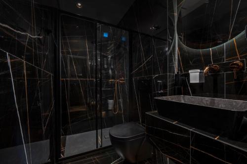 een badkamer met een douche, een toilet en een wastafel bij OMEGA SUITE in Thessaloniki