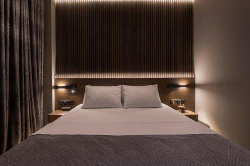 een slaapkamer met een groot bed met 2 nachtkastjes bij OMEGA SUITE in Thessaloniki