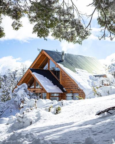a log cabin in the snow at Cabañas Bahiamia in Villa Pehuenia