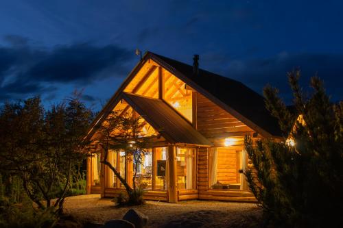 a log cabin at night with the lights on at Cabañas Bahiamia in Villa Pehuenia