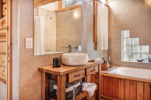 a bathroom with a sink and a tub at Cabañas Bahiamia in Villa Pehuenia