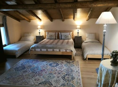um quarto com 2 camas, um candeeiro e um tapete em Feudo Algerazzi em Zafferana Etnea