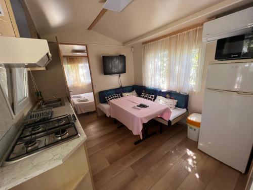 a kitchen with a table and a couch in a kitchen at Apartments and bungalows vila Dalibor in Nin