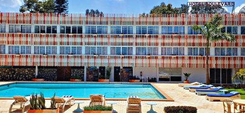 a hotel with a swimming pool in front of a building at Hotel Boulevard Nairobi, City Centre CBD in Nairobi