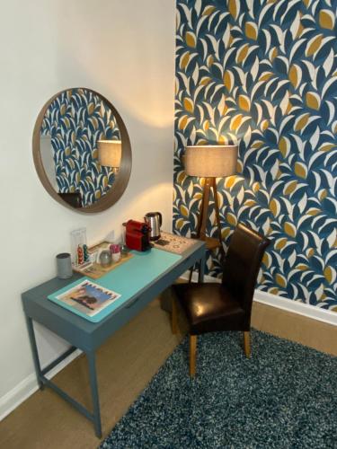 Tusson的住宿－Maison Dix Tusson，一张带椅子和镜子的蓝色书桌